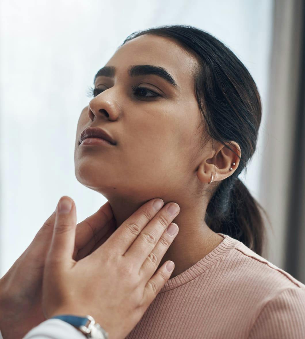 Doctor touching patient's neck