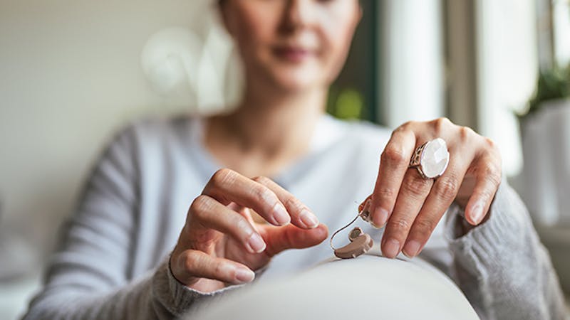 Person touching hearing aid
