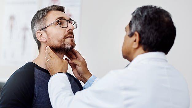 Doctor touching man's neck