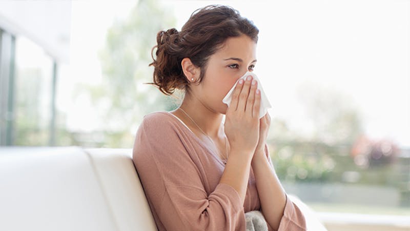 Woman blowing her nose