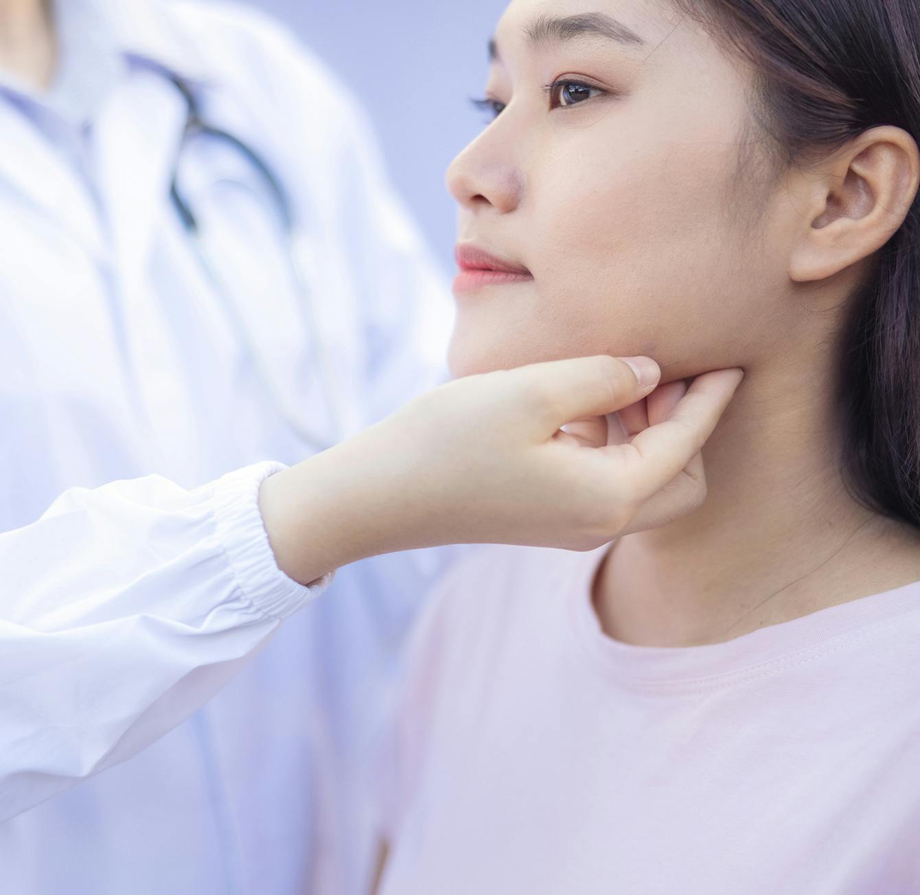 woman having her throat checked by a doctor