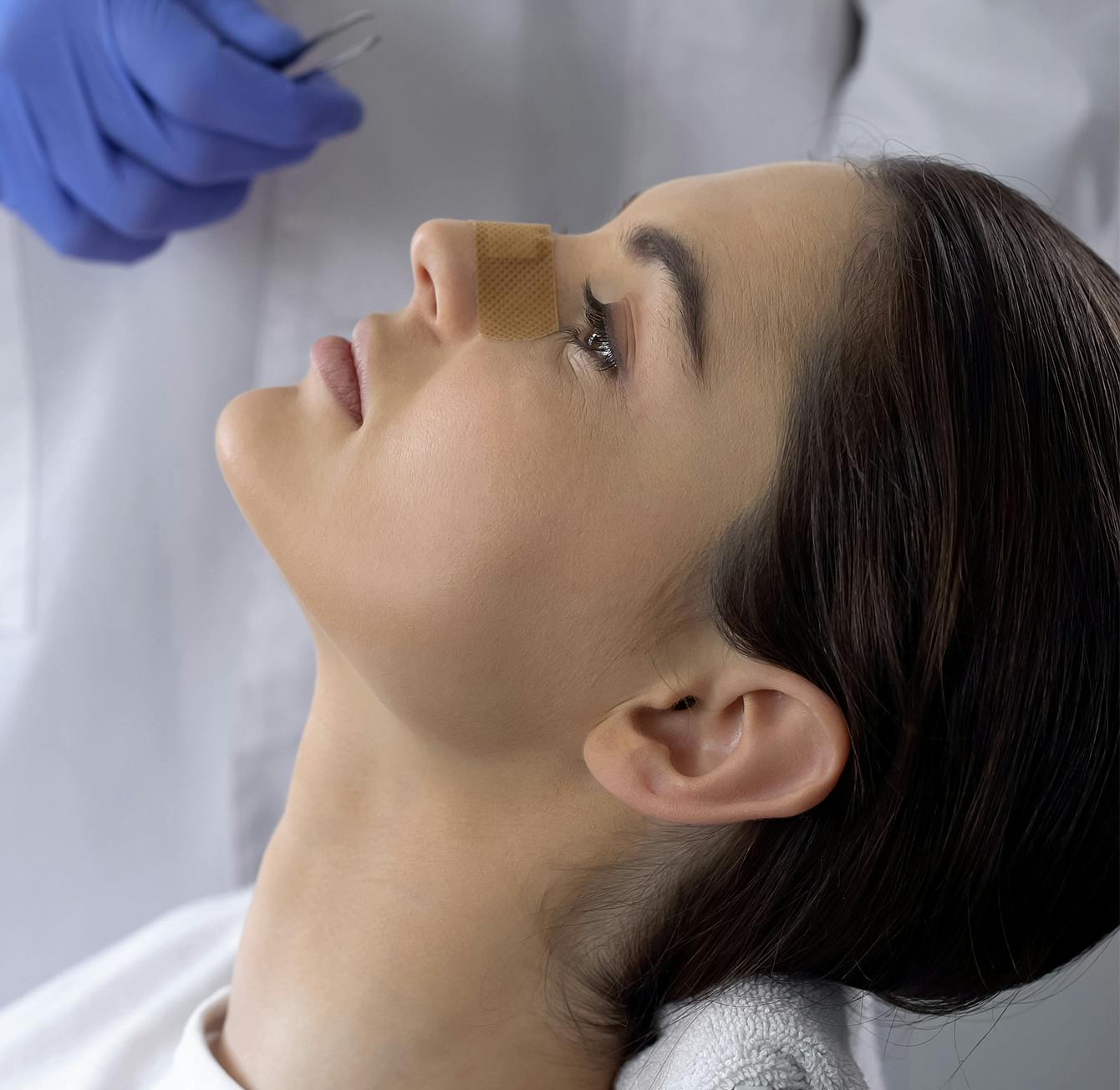 woman getting tape on her nose