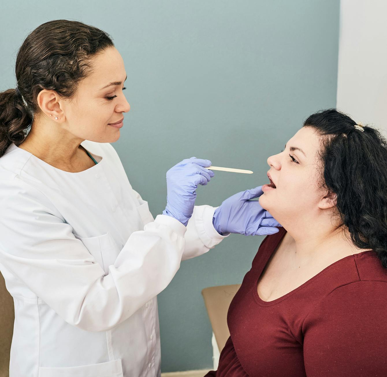 woman having her throat inspected by a doctor