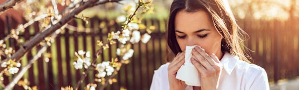 woman outside blowing her nose