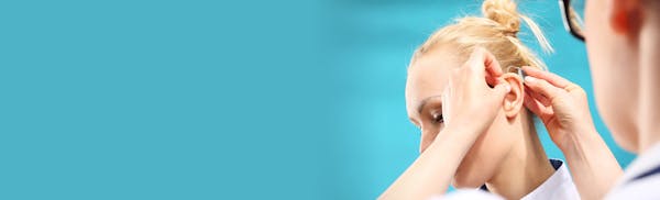 doctor inserting hearing aid