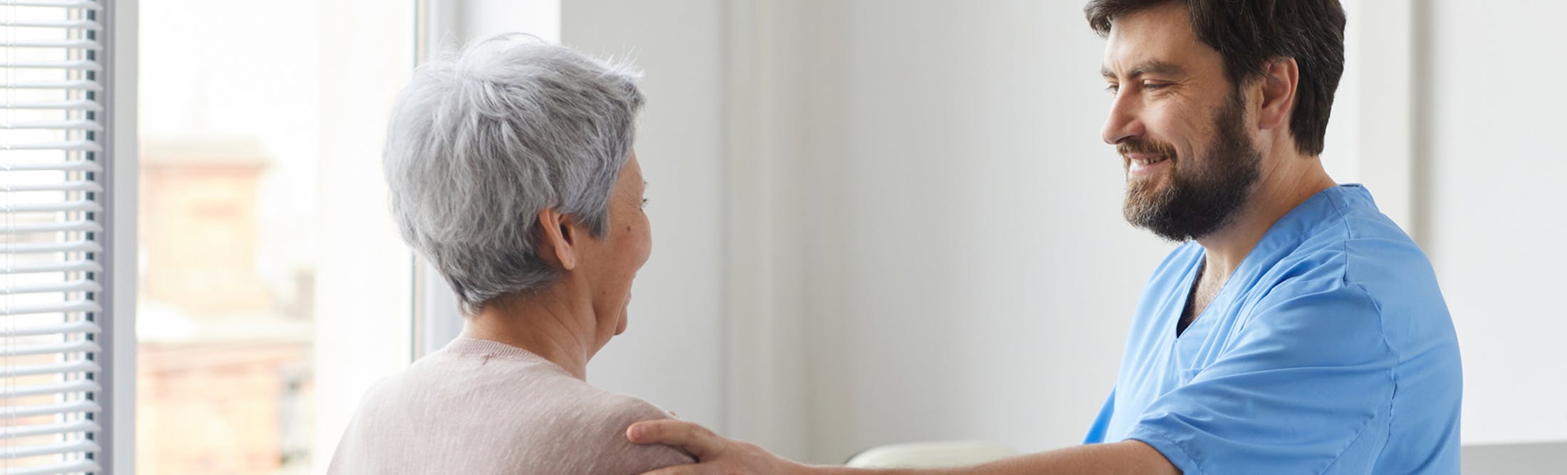 doctor talking to a patient while touching her shoulder