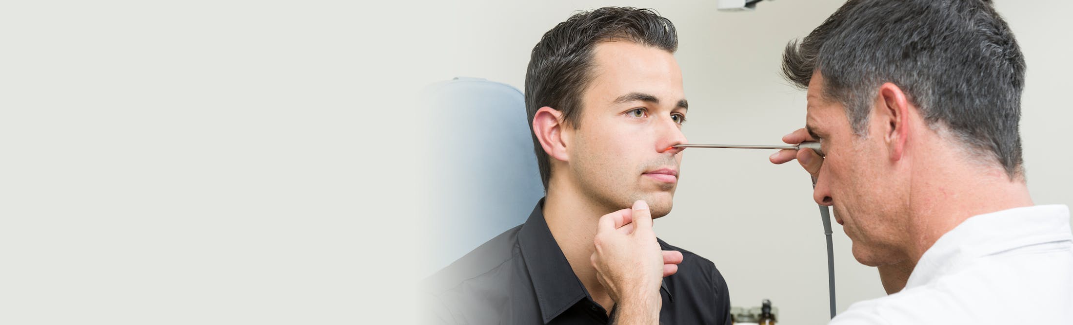 doctor checking a male patient's nose