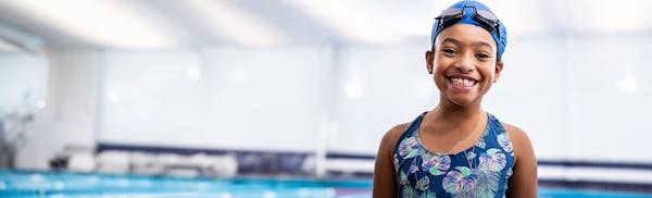 young girl in a bathing suit and swimcap