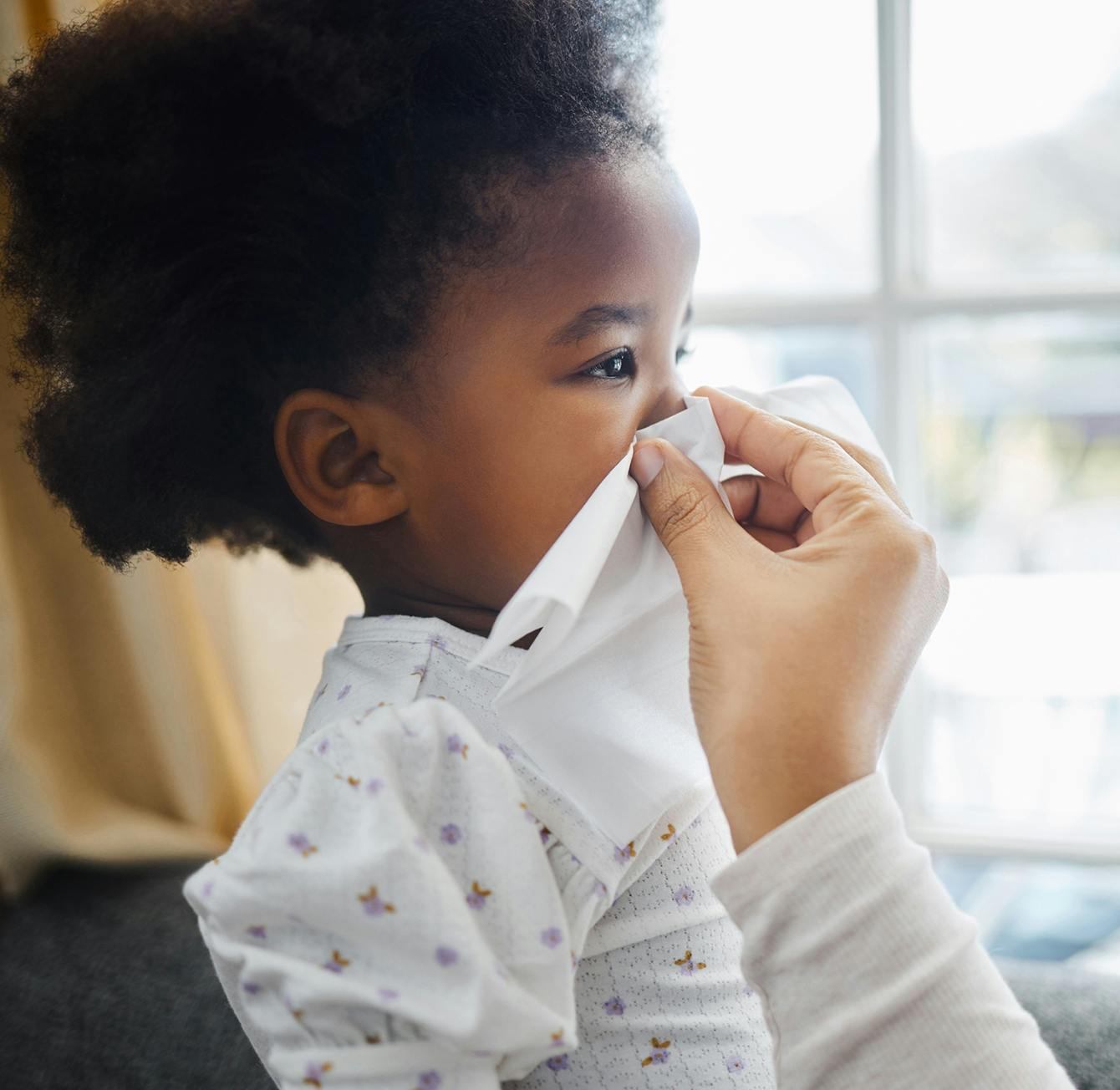 young kid blowing her nose