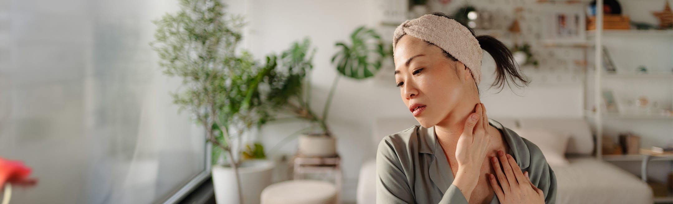 woman touching her neck in discomfort