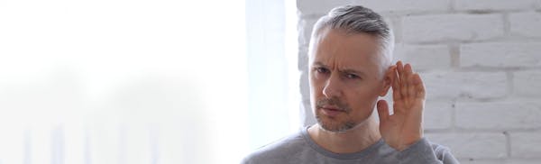 man holding his hand by his ear