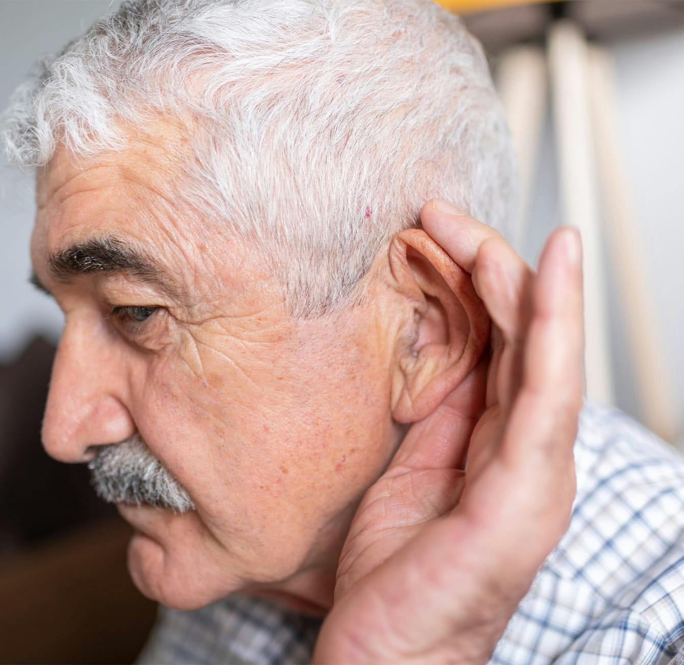 man holding his hand around his ear