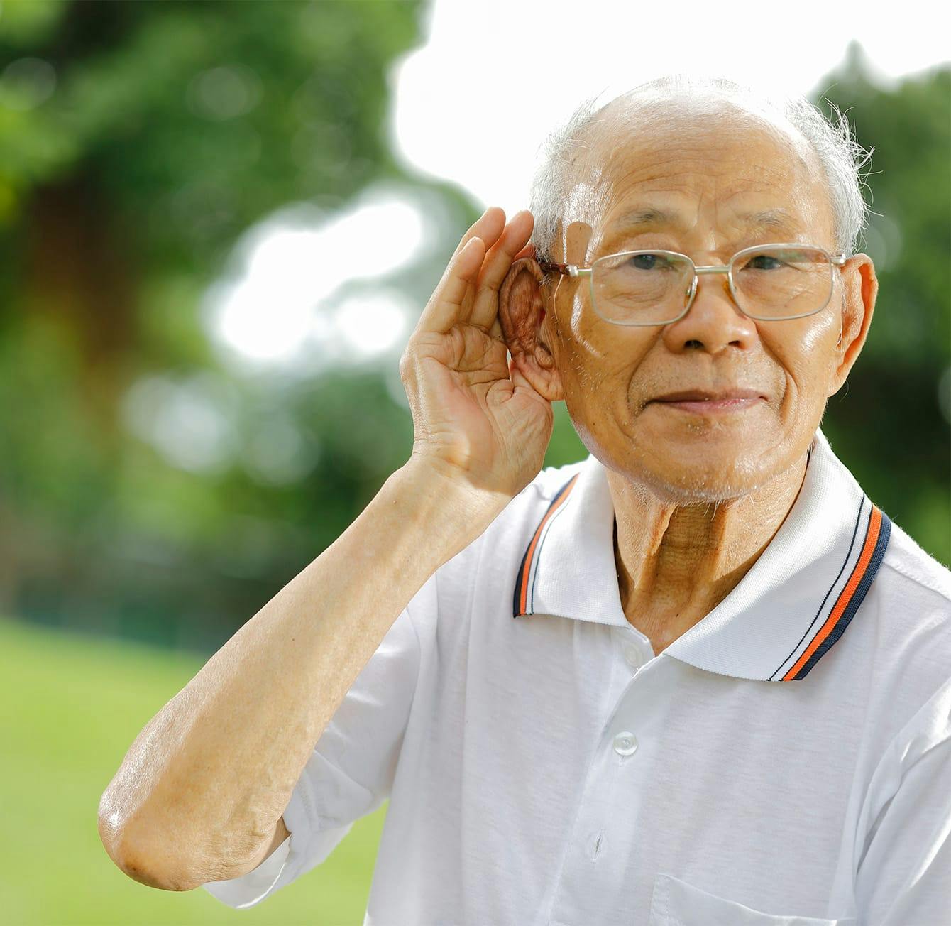 older man holding his hand by his ear