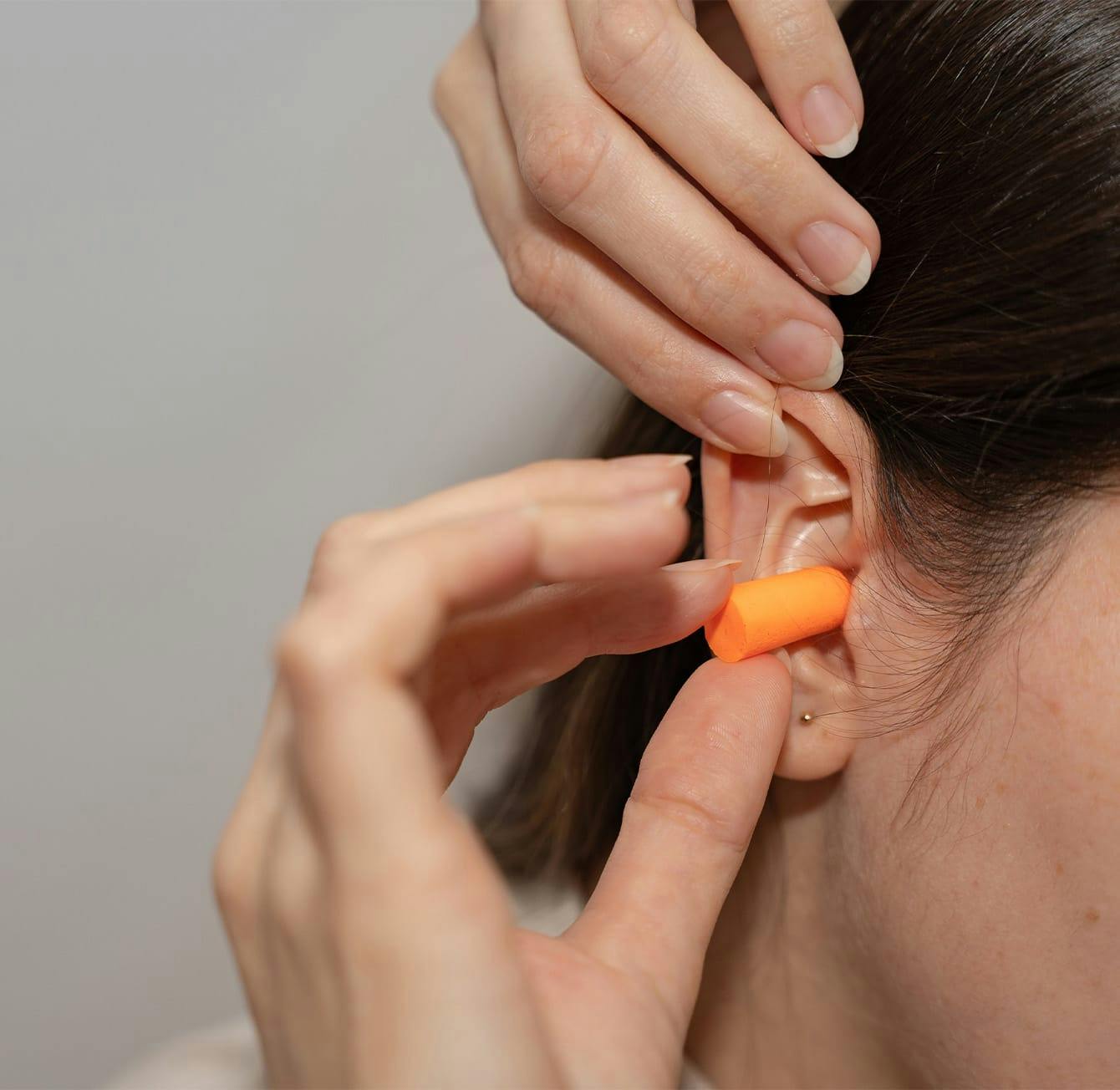 woman putting in earplugs