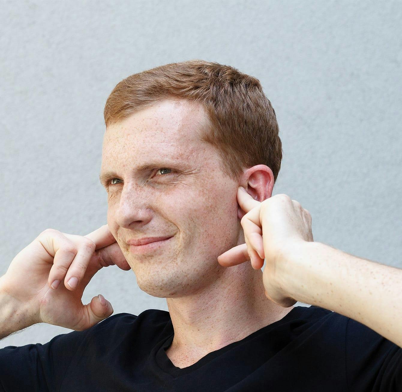 man plugging his ears