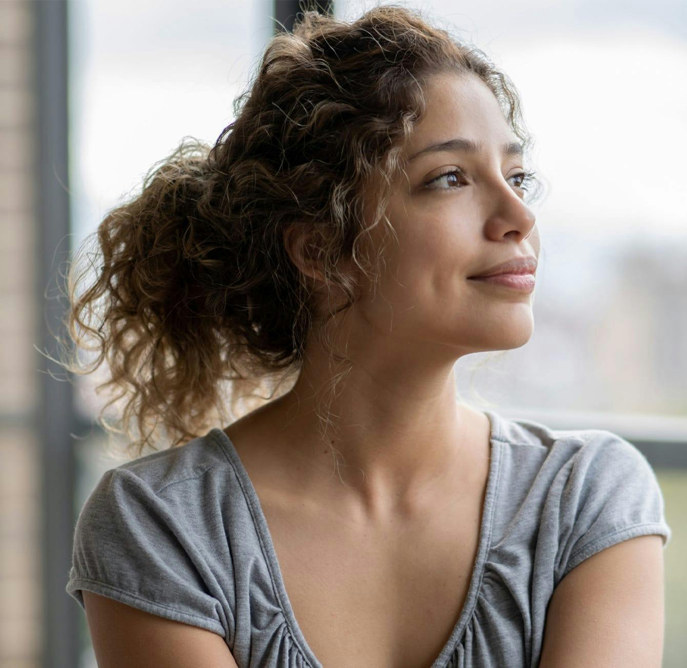 woman looking outside with her hair in a ponytail