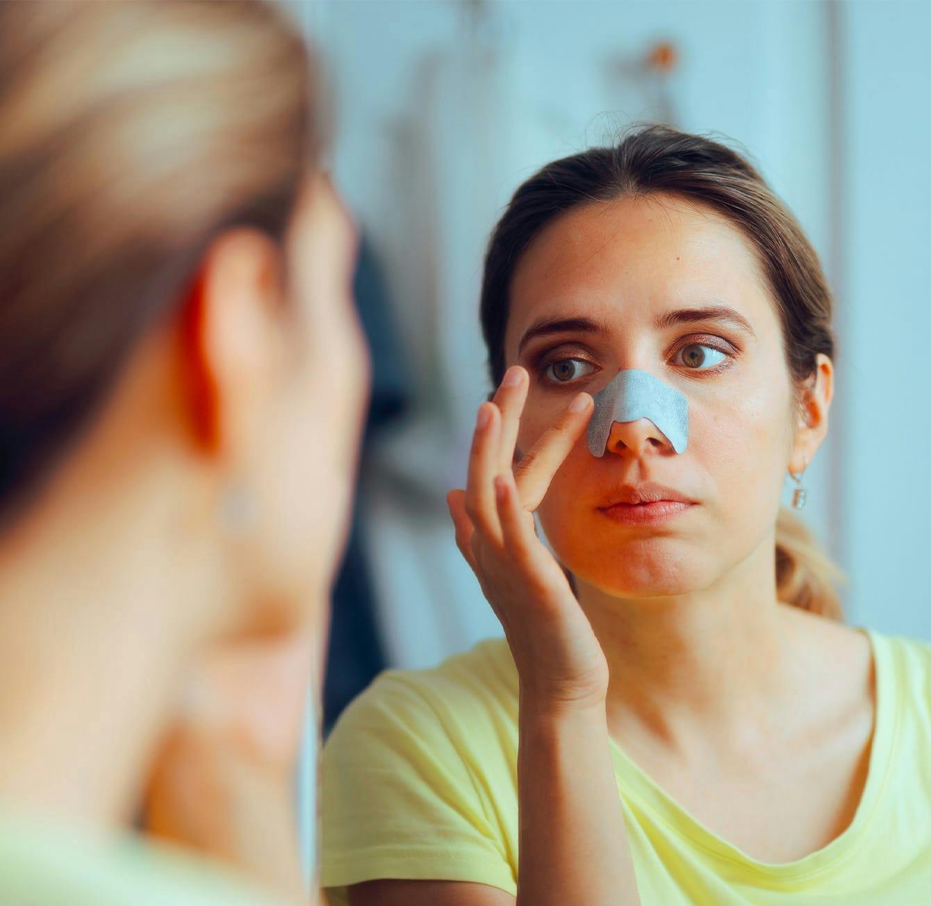 woman with tape on her nose