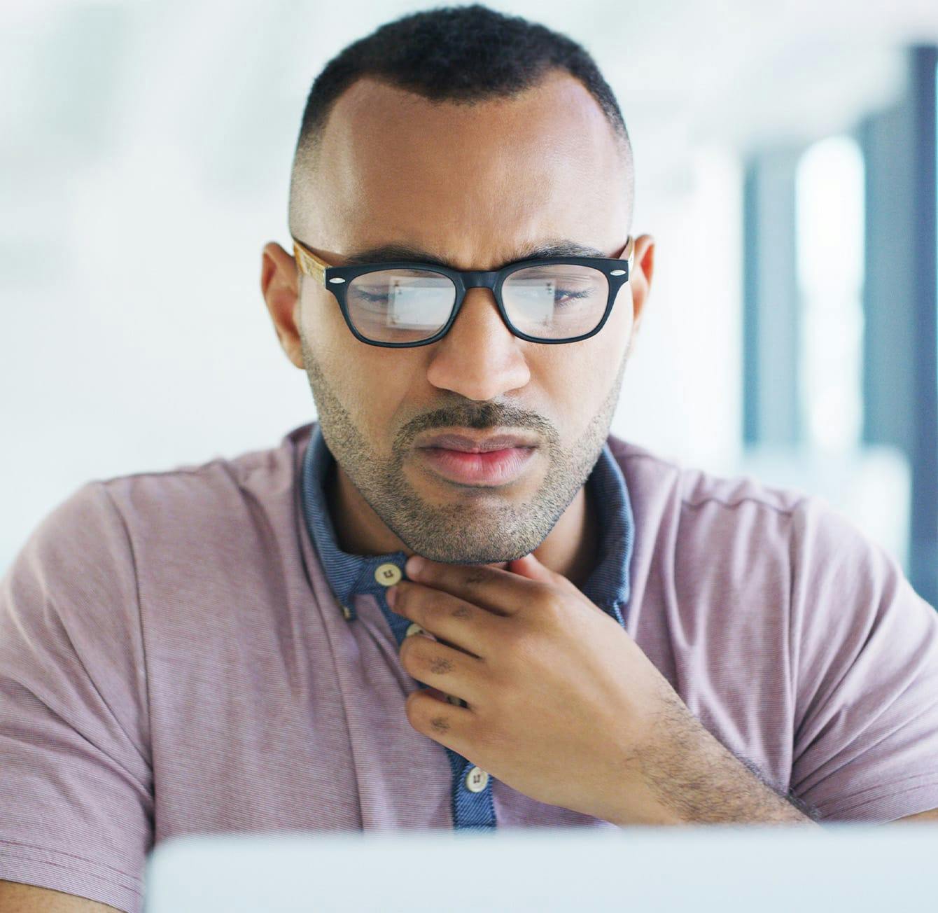 man touching his throat in discomfort