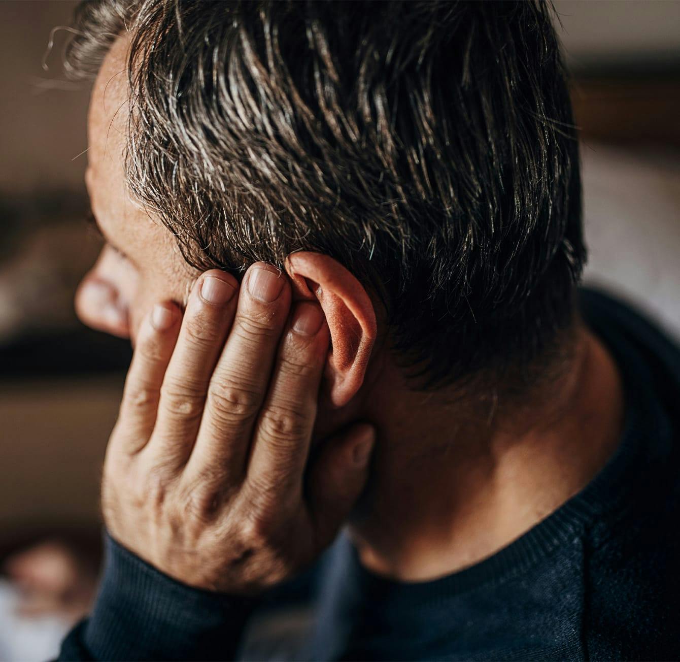 man touching his ear