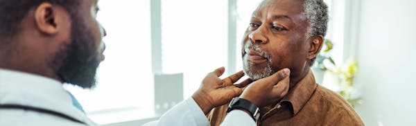 doctor checking a man's throat