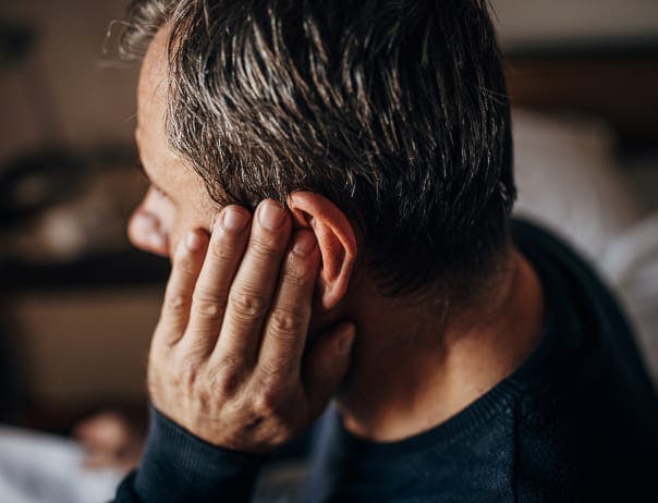 Man with his hand over his ear