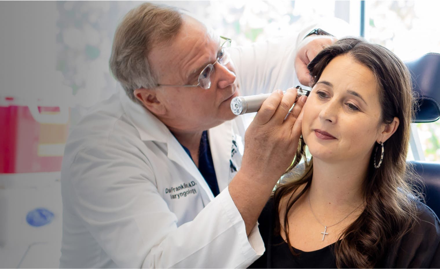 woman getting her ear checked out by a doctor