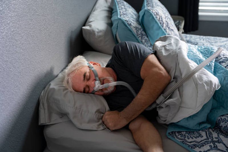 Man Sleeping with Sleep Apnea Machine