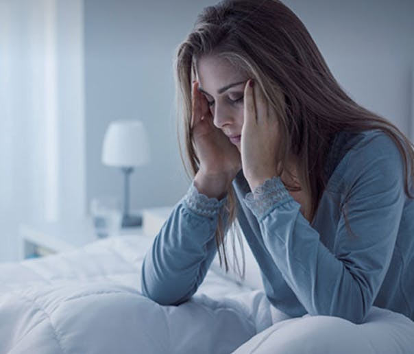 woman holding her head in discomfort