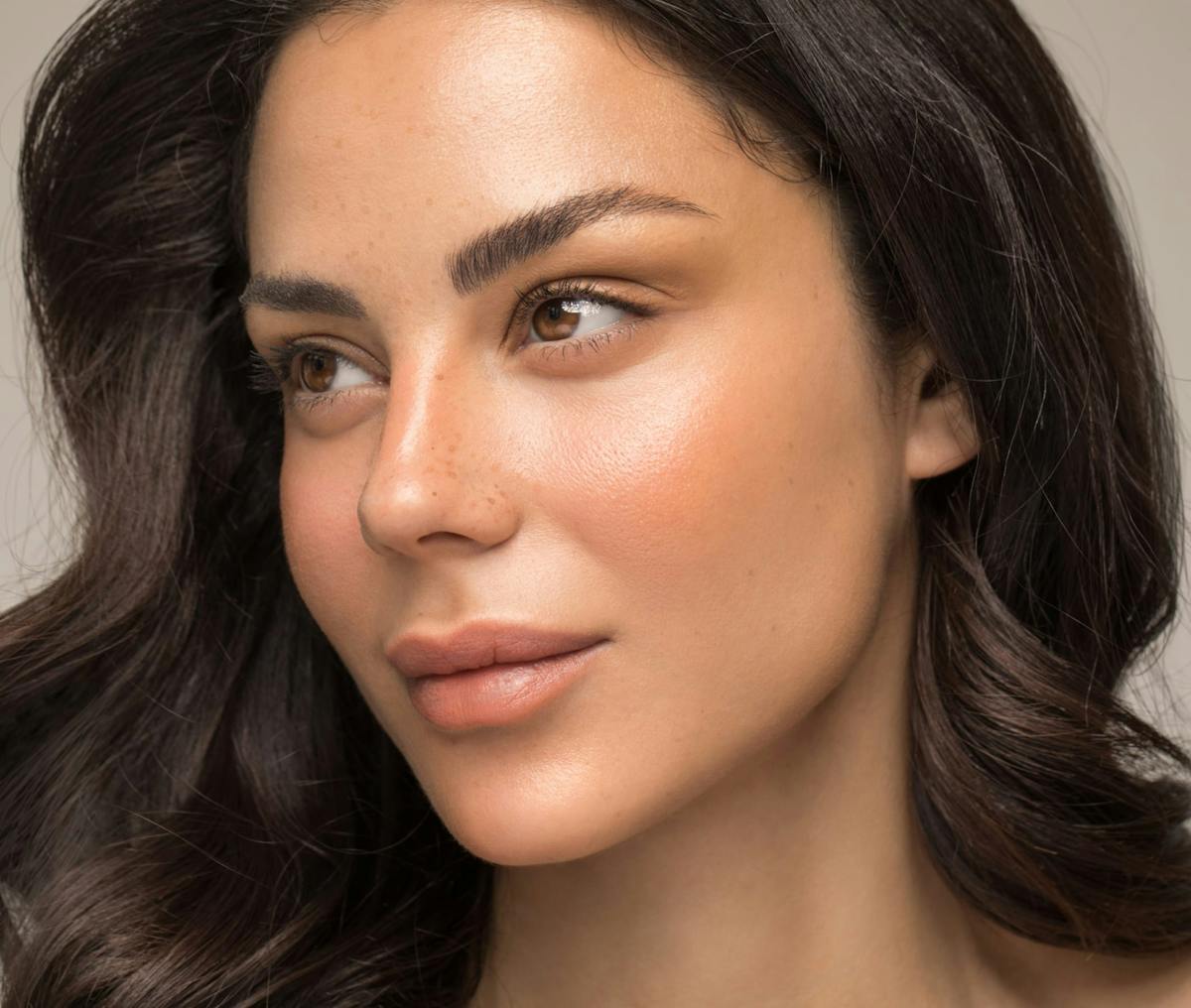 woman with dark curly hair and freckles