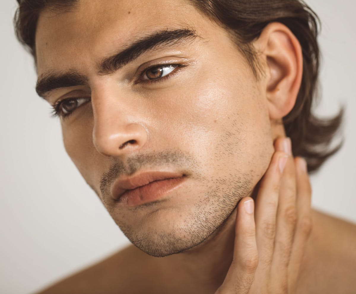 Man with beard stubble feeling chin