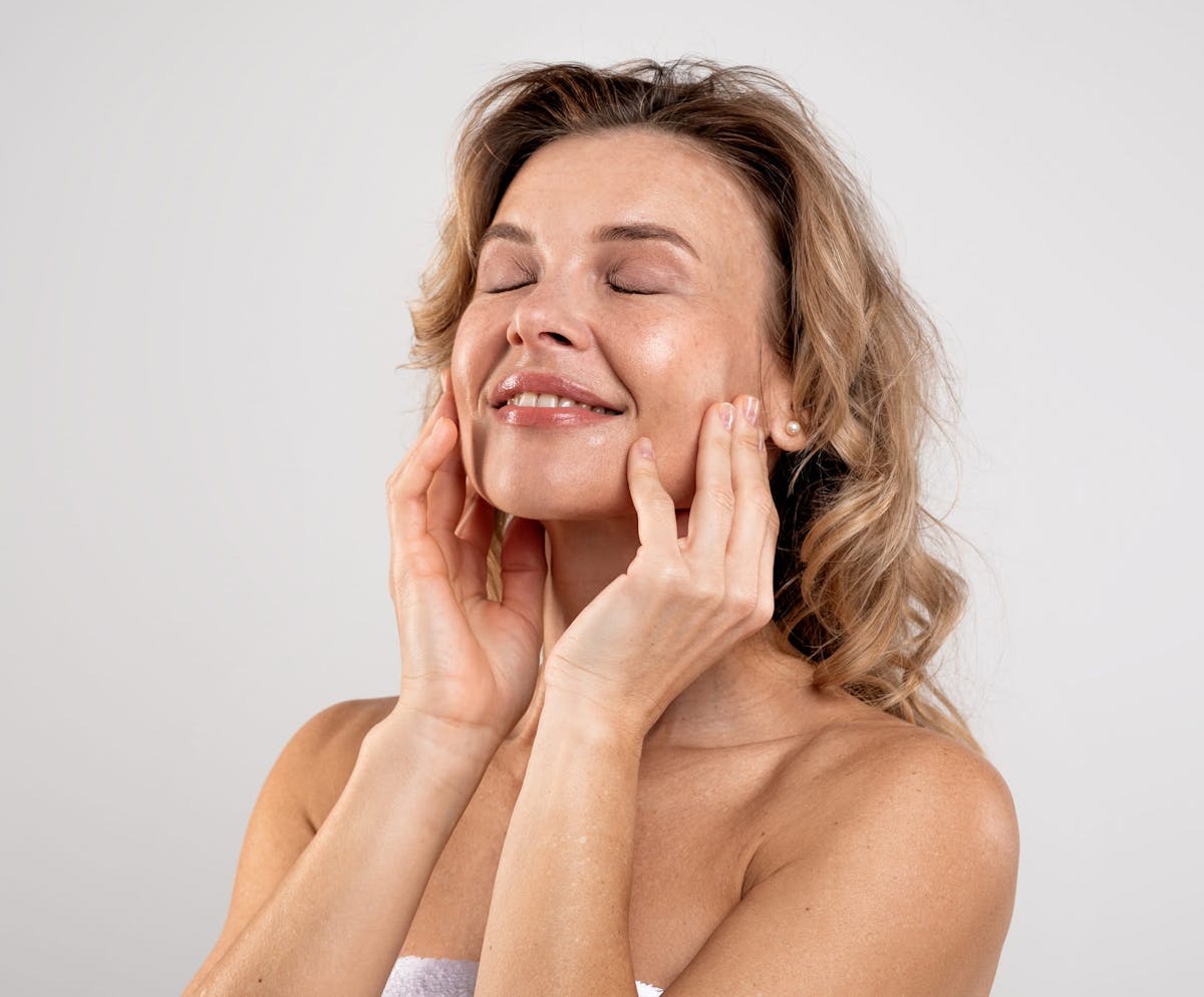 Woman smiling while holding cheeks