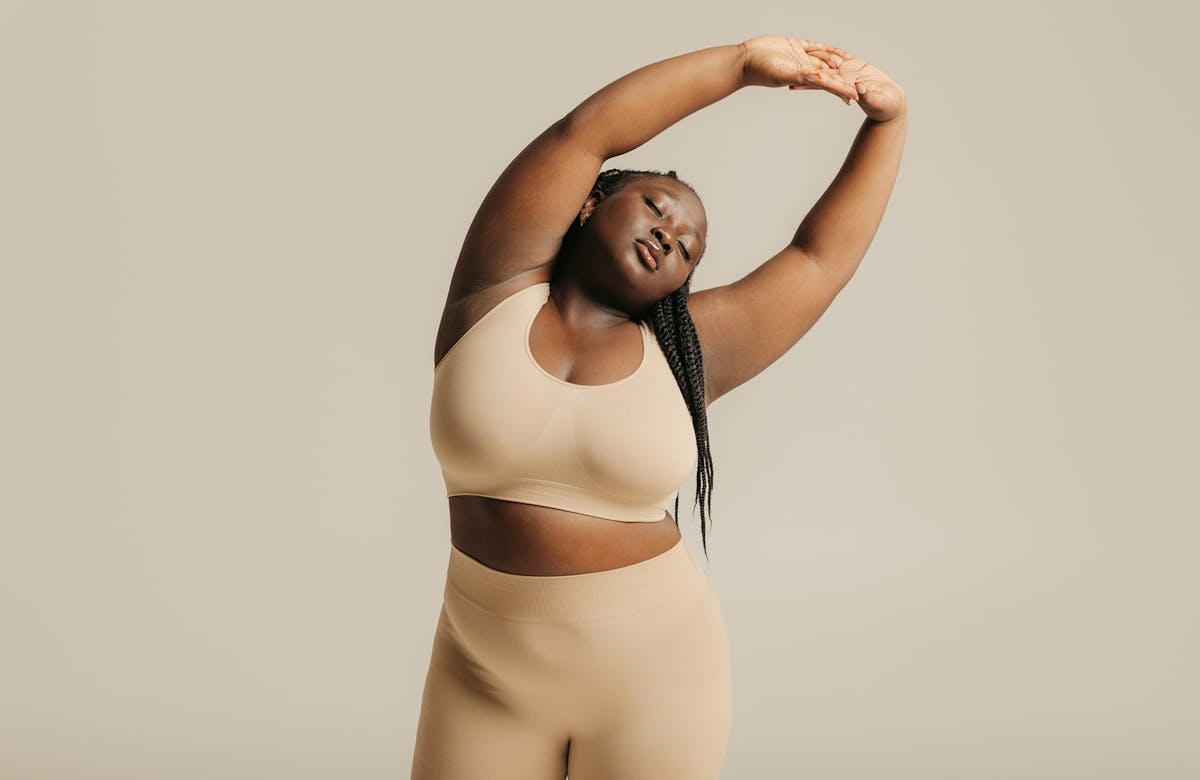 Woman stretching in tan yoga clothing