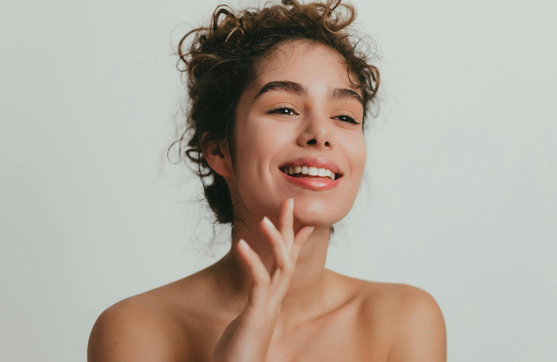 Smiling woman touching chin