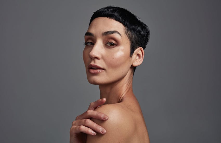 short-haired woman smiling over shoulder