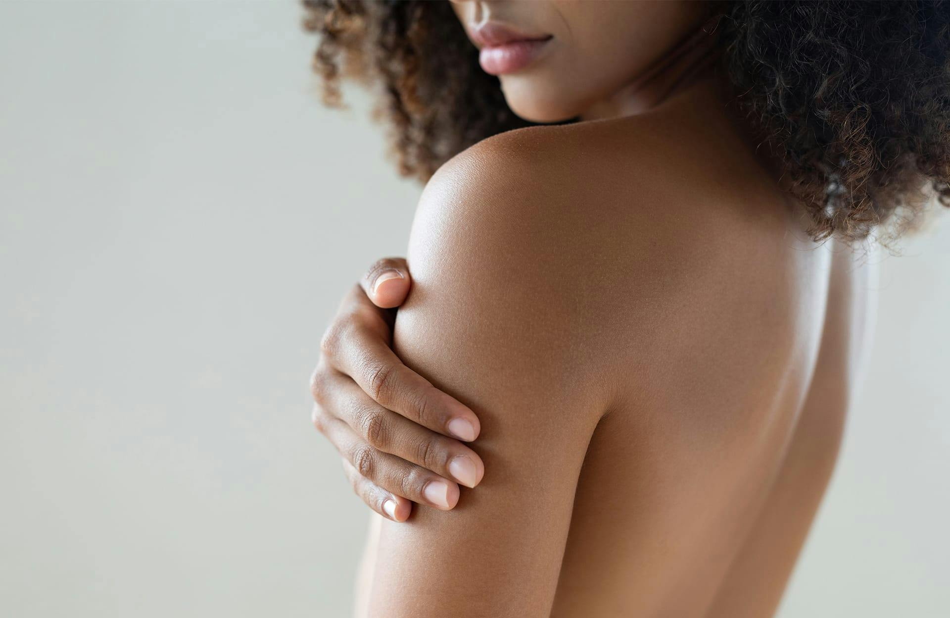 Woman holding arm below shoulder
