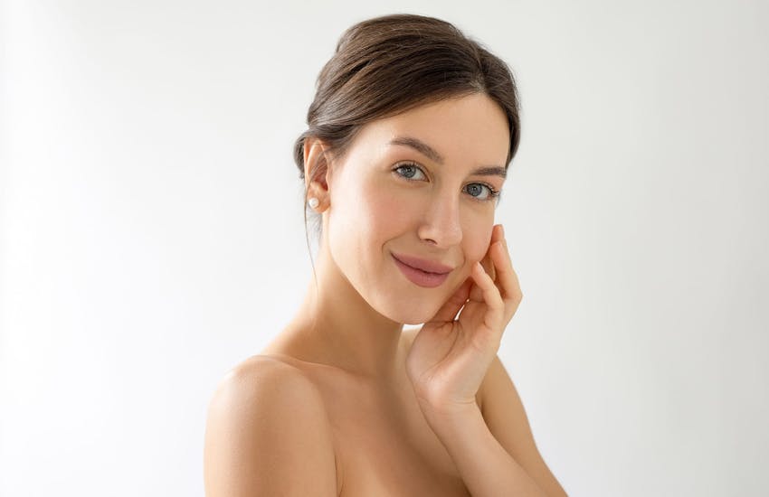 Smiling woman touching cheek
