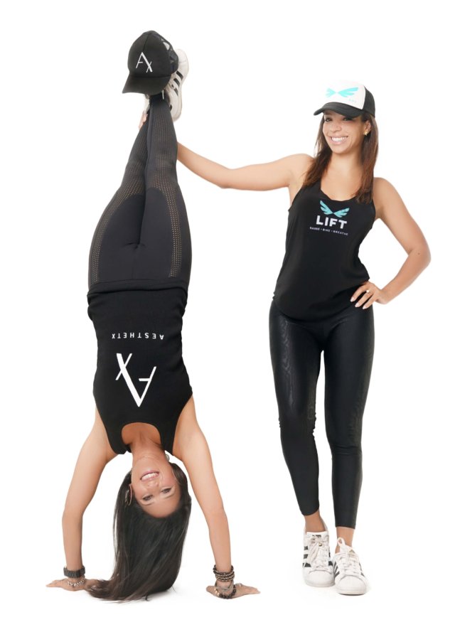 Woman helping another woman do a handstand