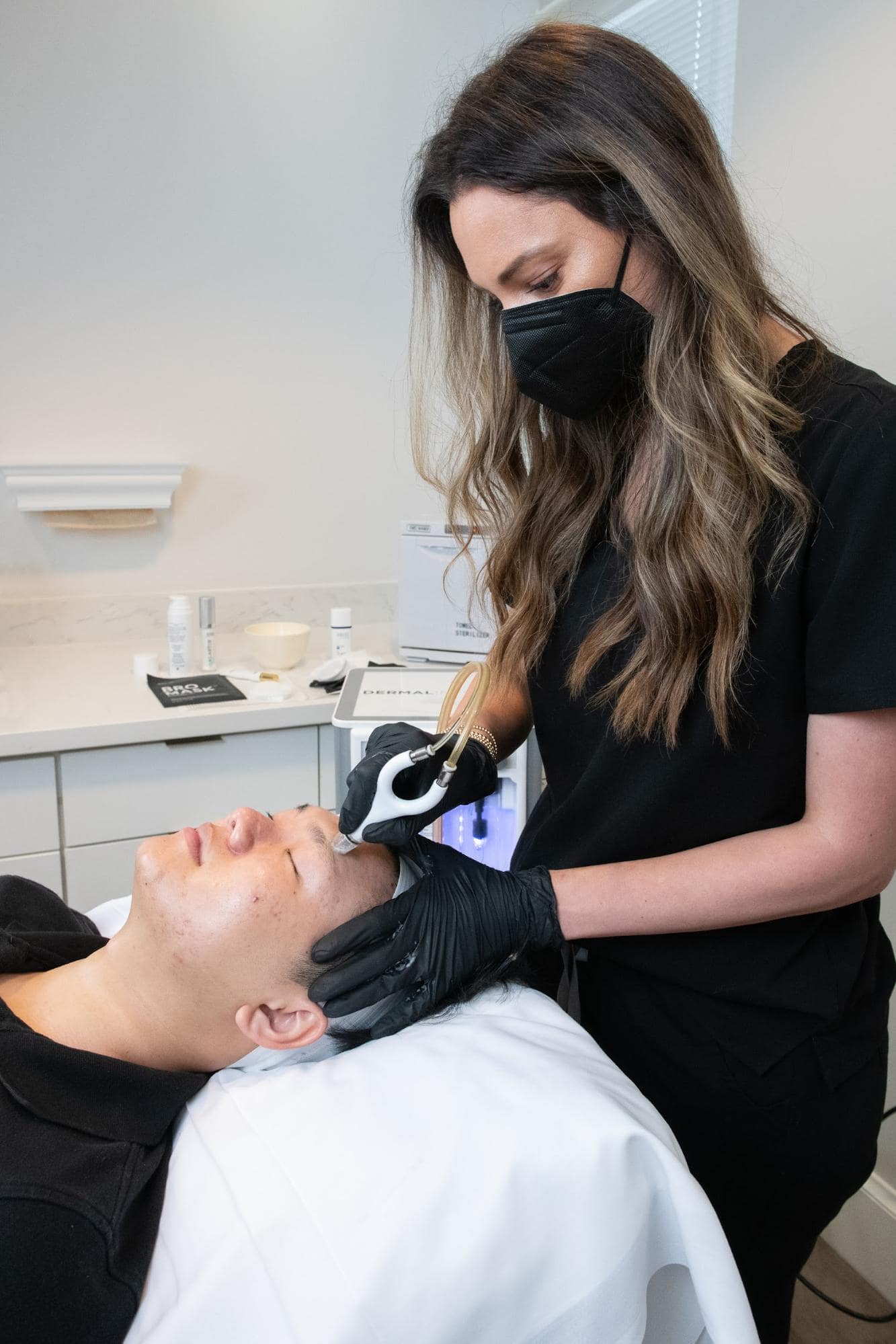 Aesthetics nurse performing a facial treatment on patient