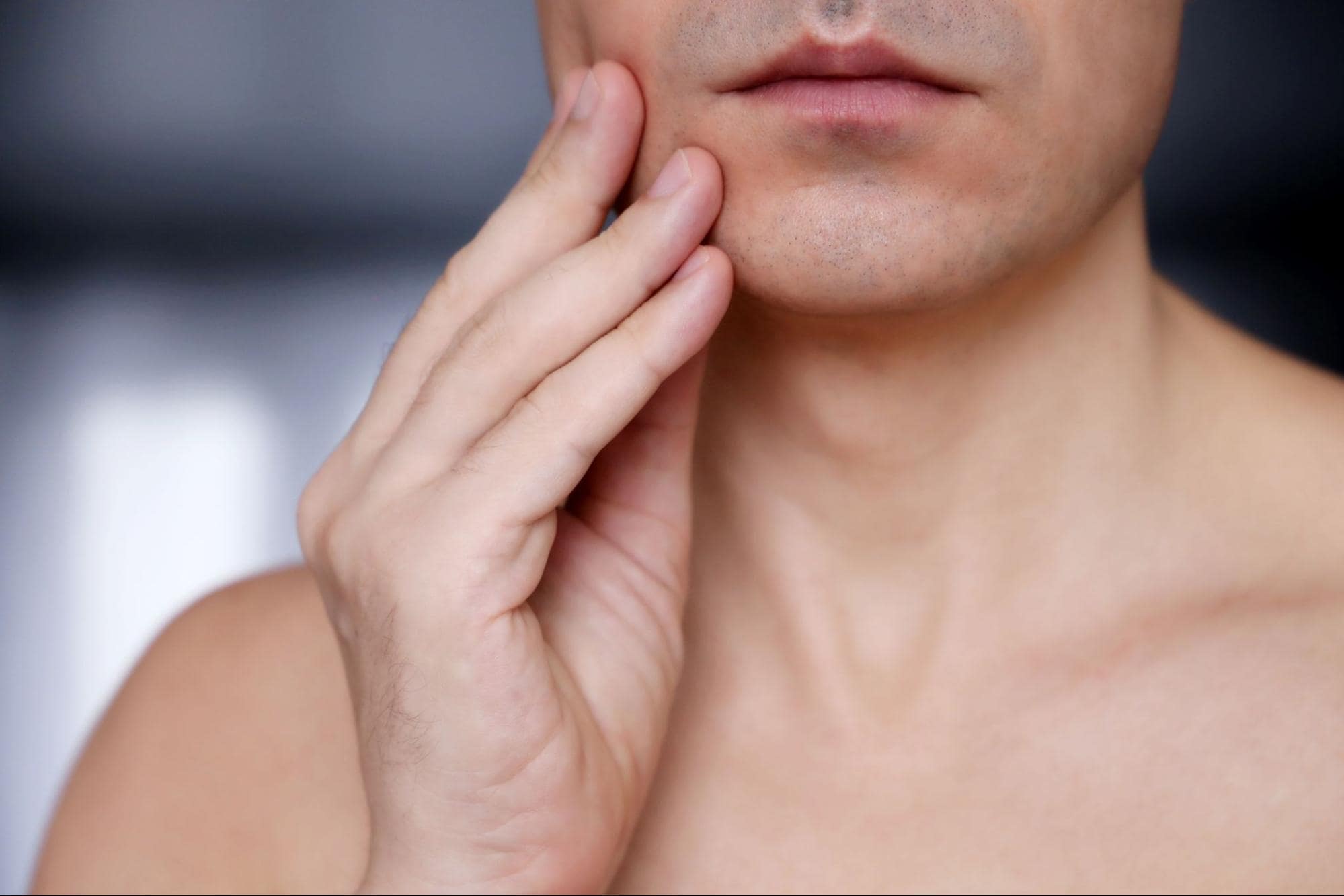 person touching their jaw