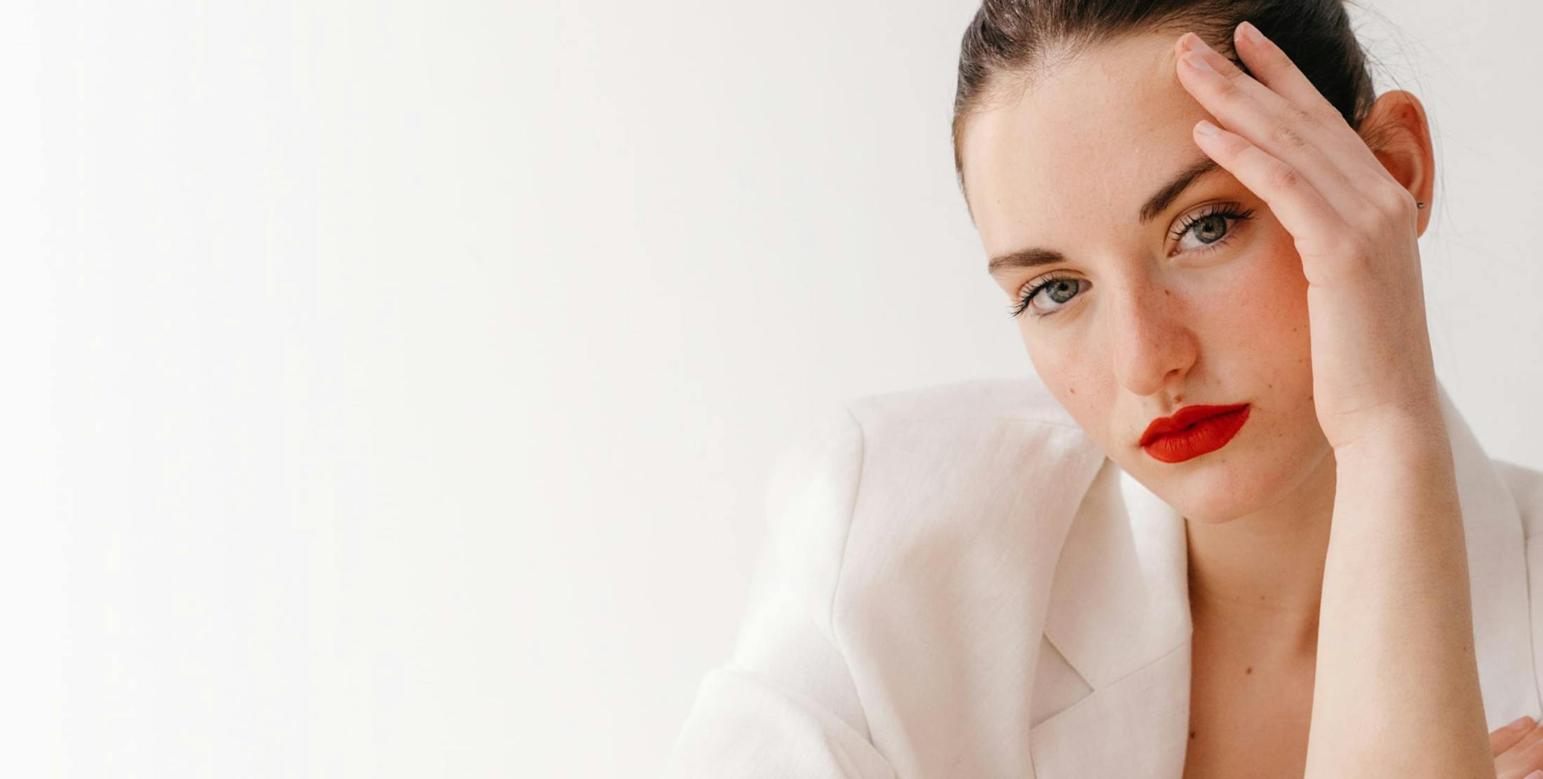 woman with red lipstick wearing a white jacket