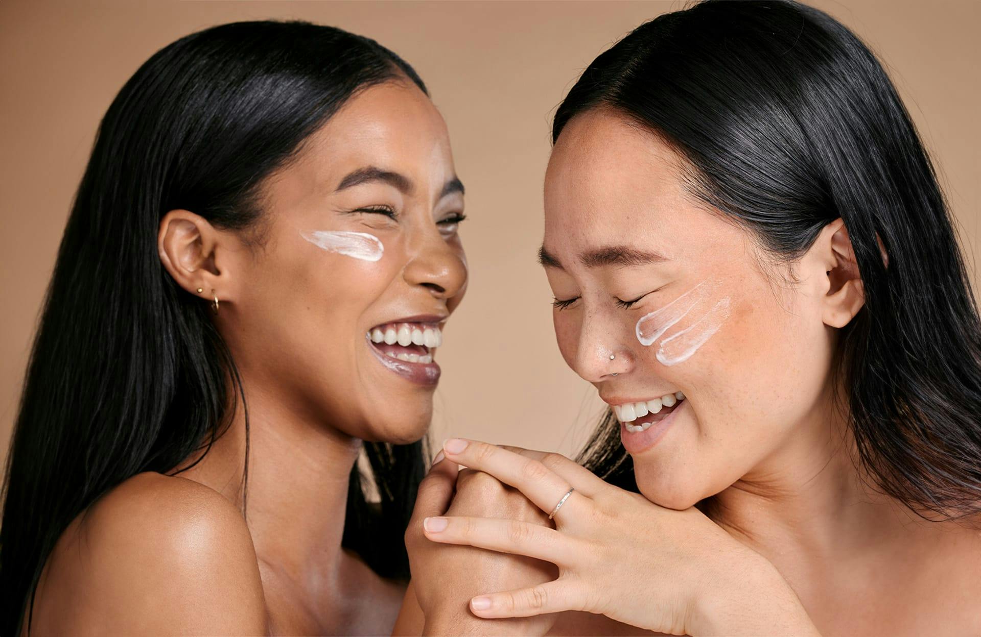 Woman rubbing cheek with cosmetic pad