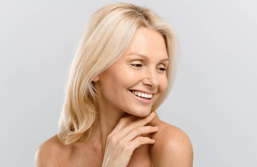 woman with blonde hair looking down to her left smiling