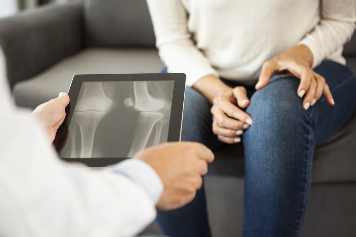 Doctor looking at x-ray results on digital tablet at a patient´s residence