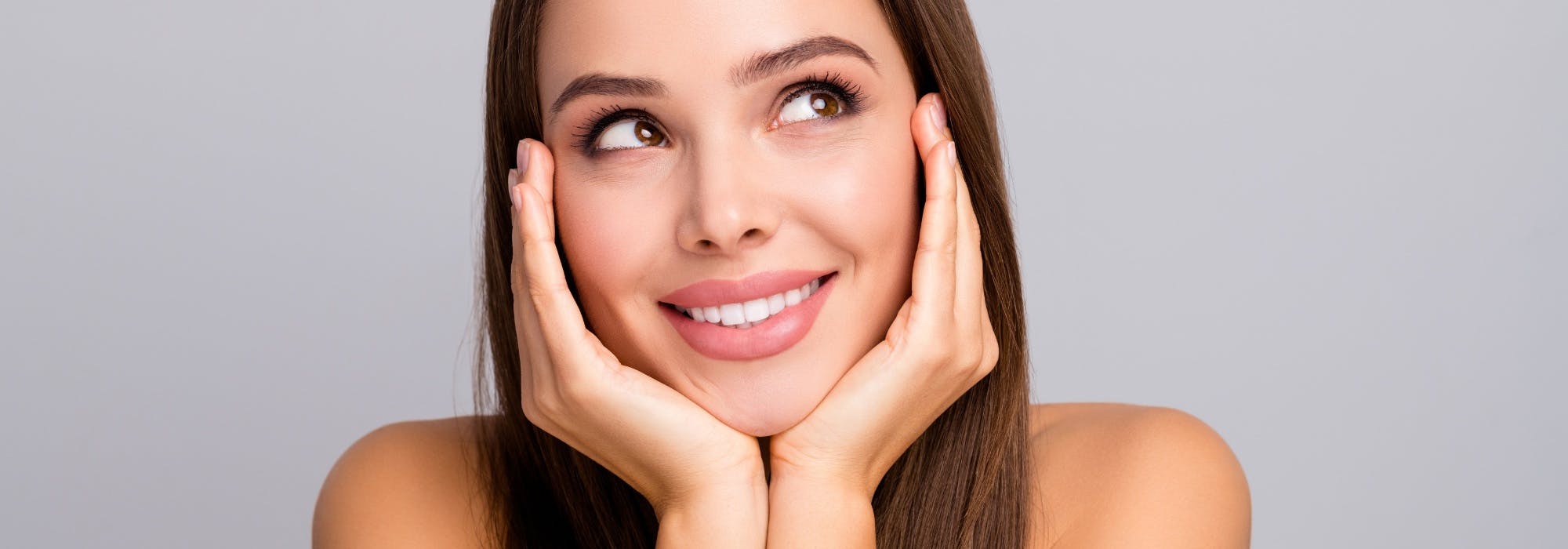 happy woman with hands cupped beneath her chin