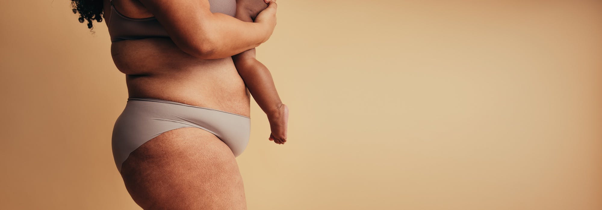 postpartum mother holds her young child