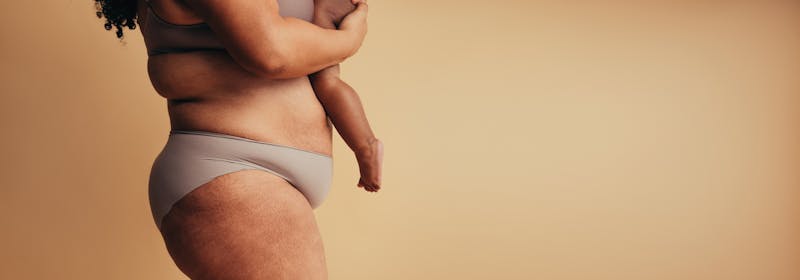 postpartum mother holds her young child