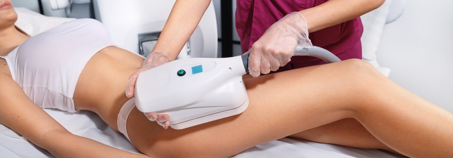 aesthetician applies nonsurgical fat reduction device to female patient's leg