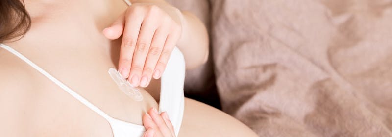 woman applies lotion to non-exposed breast