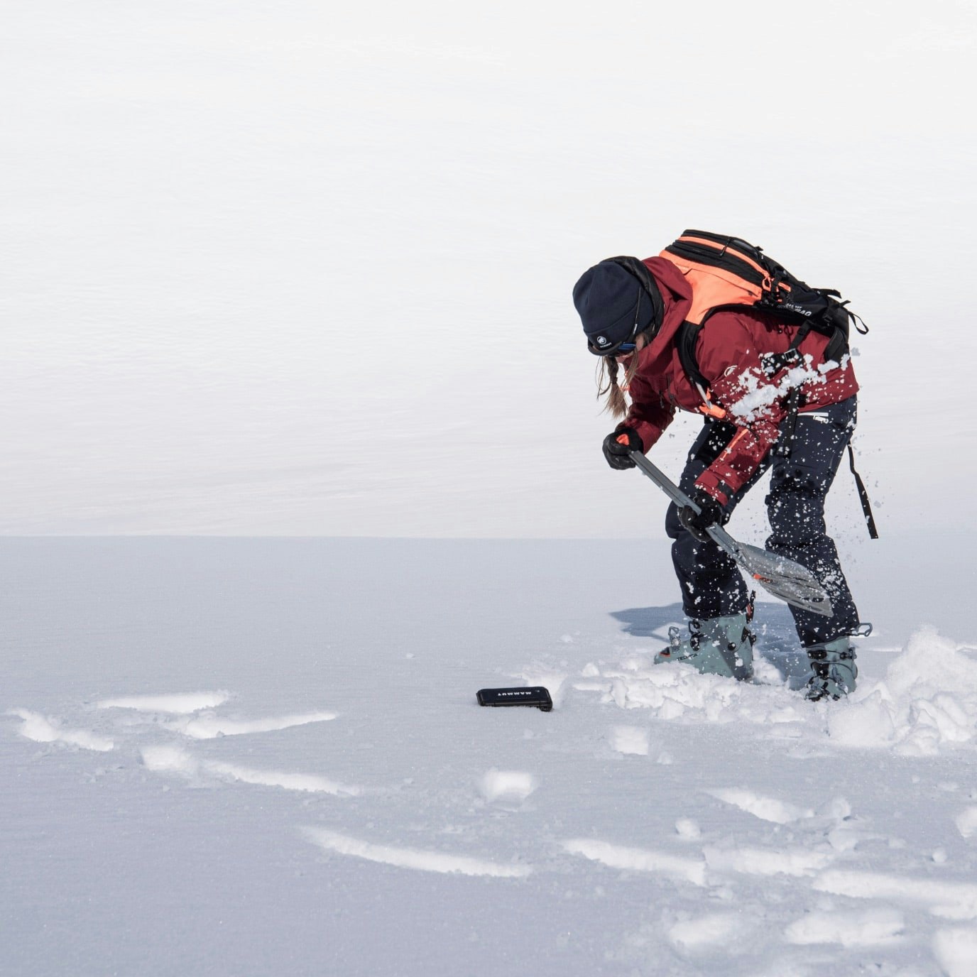 A person digging in the snow with a shovel.