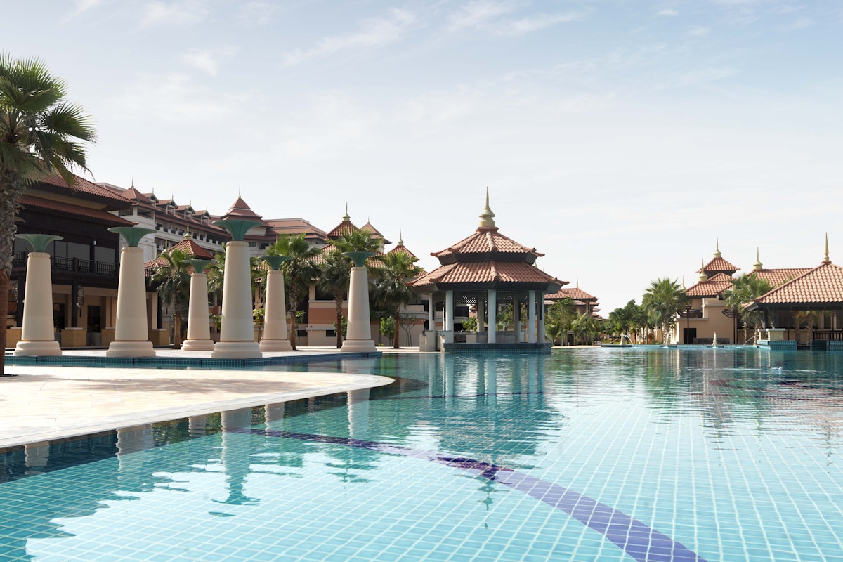 Anantara The Palm Large resort pool with traditional pavilion architecture and palm trees.